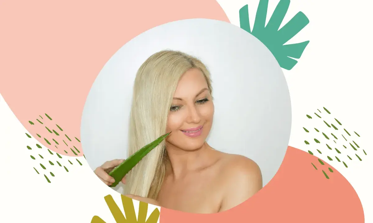 Blondynka z uśmiechem przykłada liść aloesu do swoich lśniących włosów, odkrywając jego pielęgnacyjne właściwości.