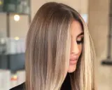 Kobieta z pięknymi, długimi włosami. Ciemne włosy z przodu przechodzą w jasny blond, tworząc subtelne refleksy.