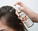 Dłoń aplikuje serum do skóry głowy, pokazując, jak używać serum do włosów dla lepszej stymulacji.