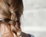 Gładki warkocz z blond włosów, który może być efektem stosowania metod, jak zmniejszyć porowatość włosów.