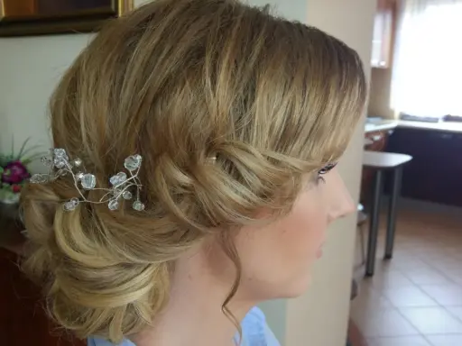 Eleganckie fryzury ślubne dla cienkich włosów: delikatny kok z kryształową ozdobą.