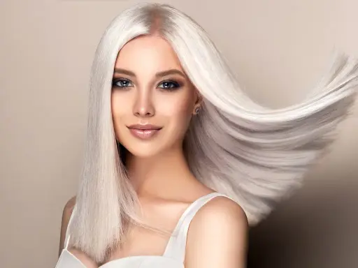 Kobieta z olśniewającymi, długimi włosami w odcieniu perłowy blond, które falują na wietrze.